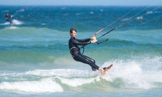 Modalidade envolve surfar com um paraquedas que permite manobras mais altas