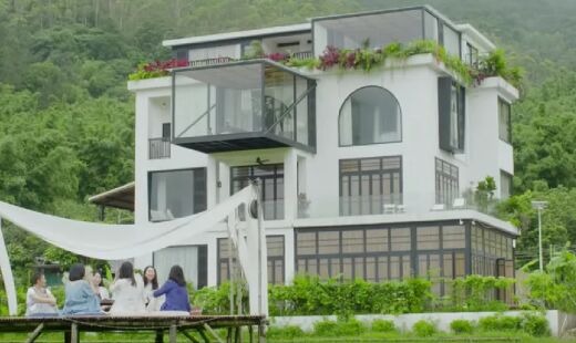 Casa, que ocupa três andares e meio, está situada em uma área cercada por colinas e arrozais