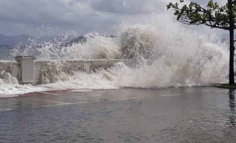 Ressaca em Santos, com mar avançando sobre a calçada e avenida da Orla