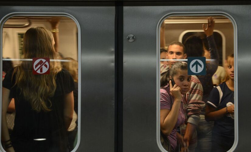 Pessoas dentro de um vagão no Metrô de SP