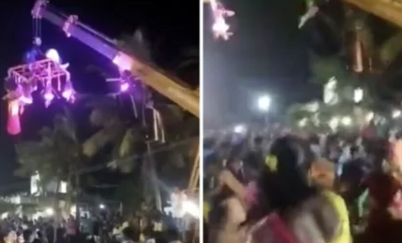 As pessoas penduradas no guindaste distribuíam guirlandas de flores aos devotos
