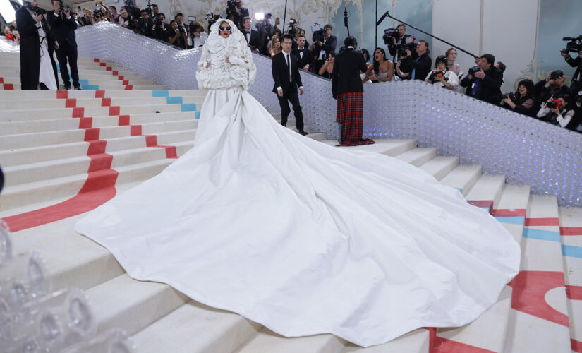 Rihanna usou um longo vestido branco da Valentino com cauda de cinco metros de comprimento e um casaco de 30 camélias (um dos códigos da Chanel) feitas de 500 pétalas