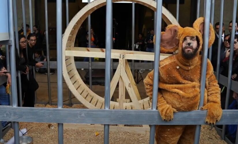 O humorista Diogo Defante vestido de rato numa gaiola gigante no meio da avenida Paulista