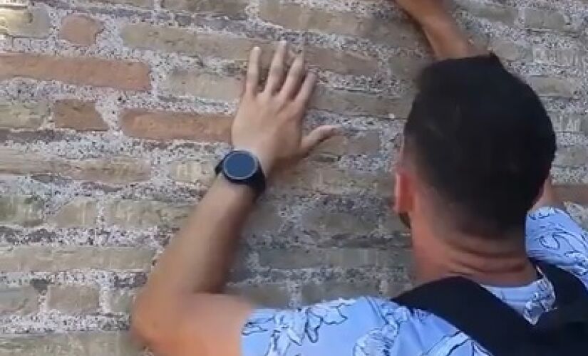 Homem de nacionalidade desconhecida vandaliza muro do Coliseu, em Roma