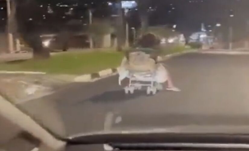 Mulher desce rua de Guaxupé a bordo de um carrinho de bebê