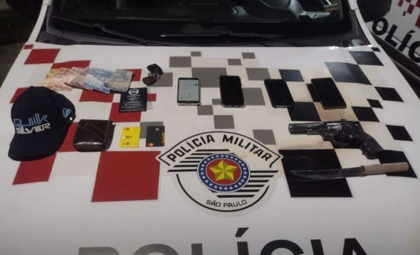 No interior do veículo foram encontrados um simulacro de arma de fogo, uma faca, quatro celulares e uma carteira com documentos e cartões