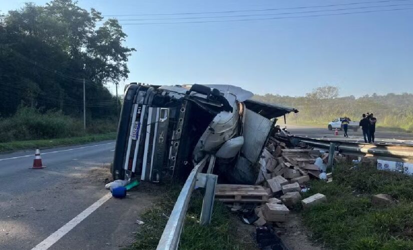 Caminhão tombou com produtos de limpeza no canteiro central e na rodovia