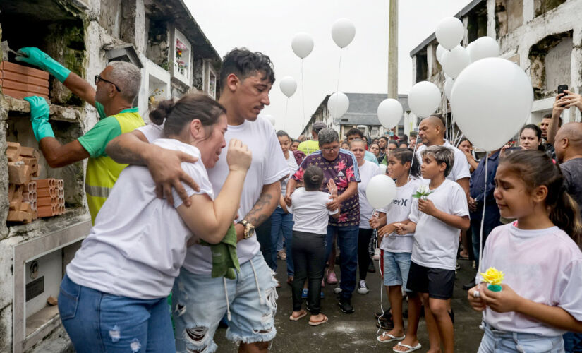 Corpo da criança foi recebido com fogos de artifício e balões brancos,no cemitério da Areia Branca, em Santos 