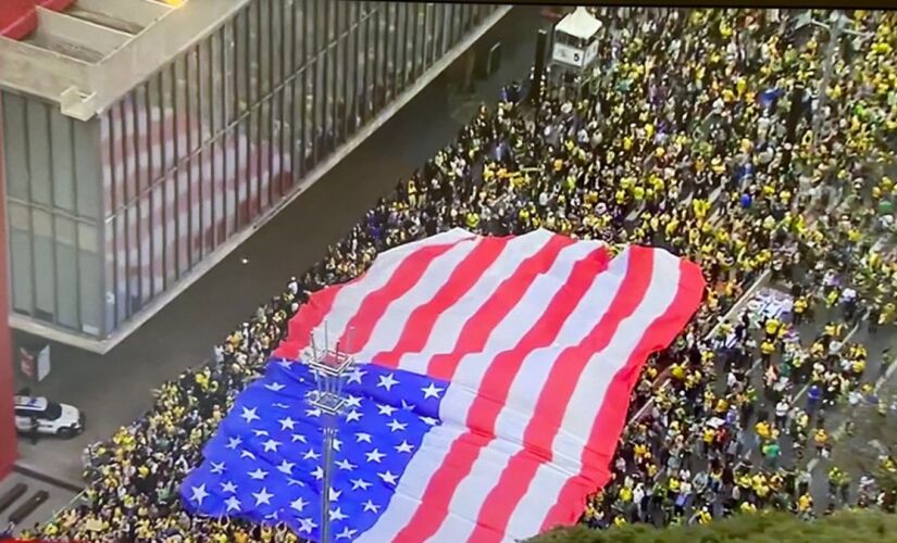 Manifestantes abrem bandeira norte-americana na avenida Paulista