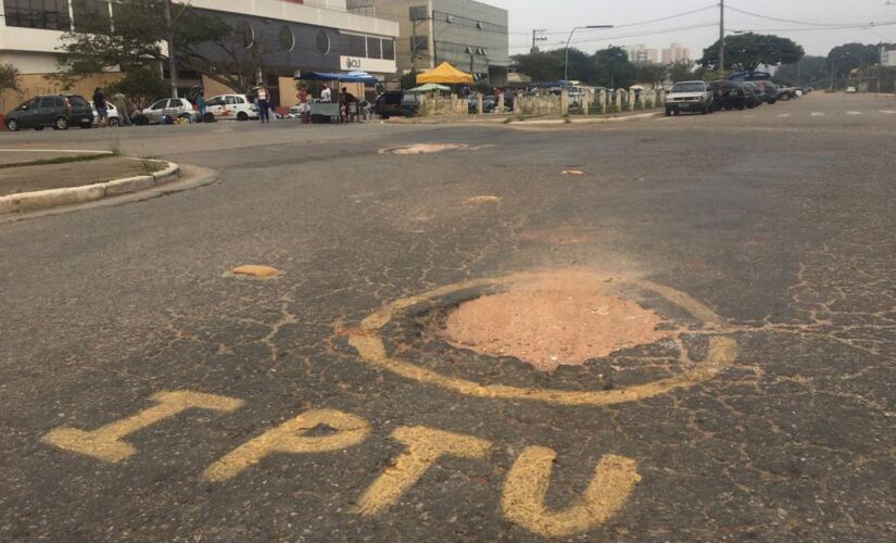  Buraco em rua de Guarulhos foi pichado com a palavra IPTU