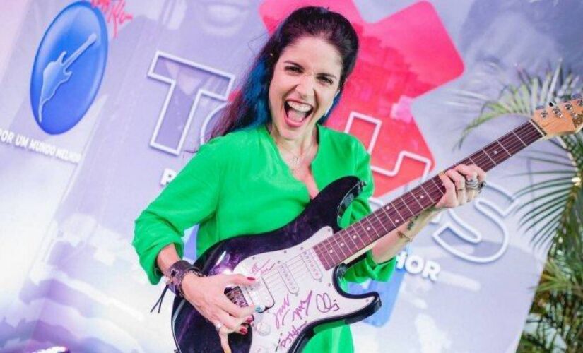 Roberta Medina, vice-presidente do Rock in Rio, com a guitarra autografada do Maroon 5, que está à venda no leilão 