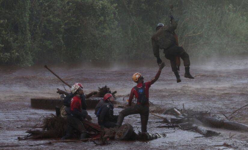 Militar resgata bombeiros que trabalhavam na busca de vítimas da barragem de Brumadinho, em 2019