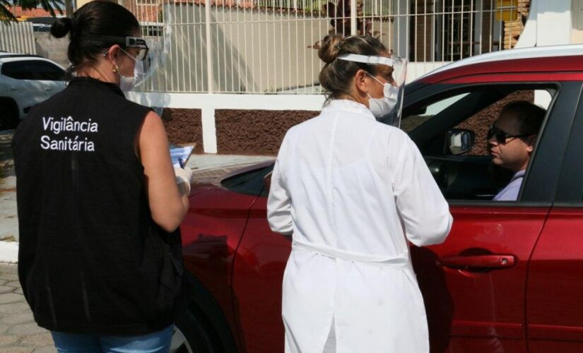 Funcionários da Saúde verificam temperatura de motorista