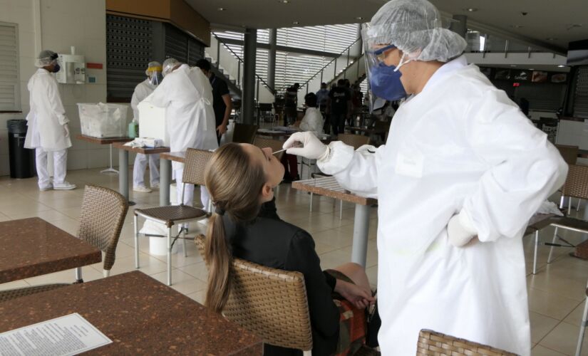 Profissionais de saúde realizam testes para detecção do novo coronavírus em Brasília; Brasil tem mais de 1 milhão de casos