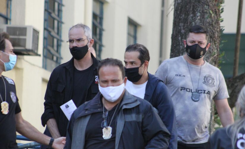  Ricardo Nunes, atrás do policial, é levado ao IML em São Paulo