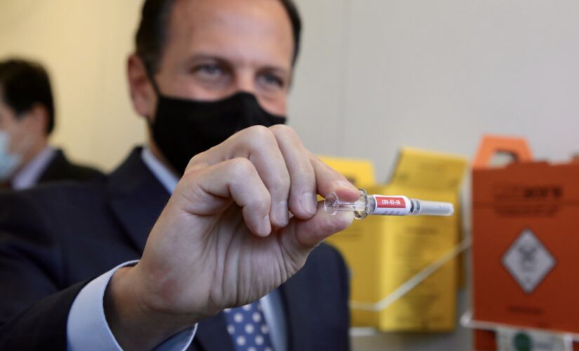 Governador Jo&atilde;o Doria (PSDB), em foto de julho deste ano, com amostra da vacina desenvolvida pelo laborat&oacute;rio Sinovac
