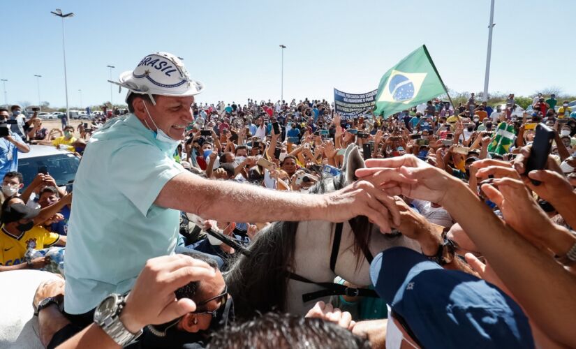 O presidente Jair Bolsonaro (sem partido) em meio à aglomeração em aeroporto nesta quinta-feira