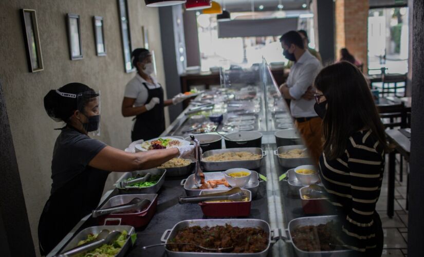 Clientes almoçam em restaurante self service após coronavírus