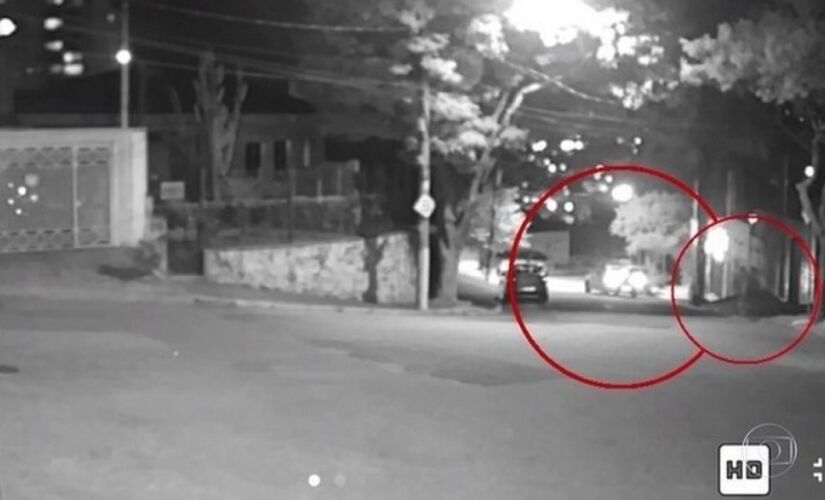 Um dos homens se aproxima do carro da vítima de 24 anos, que dá ré na tentativa de fugir e atinge outro veículo estacionado