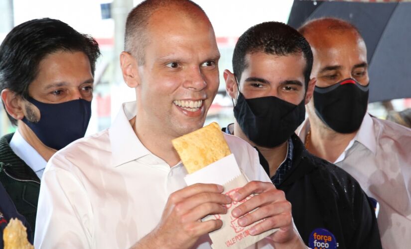 O candidato &agrave; reelei&ccedil;&atilde;o Bruno Covas (PSDB) come pastel durante caminhada na zona sul da Capital