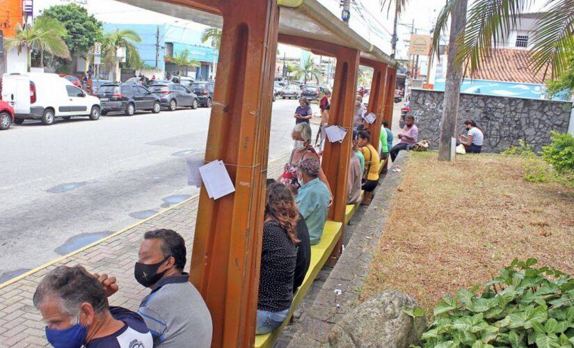 Diversas pessoas aguardam nos pontos de ônibus na avenida Condessa de Vimieiros, no Centro de Itanhaém