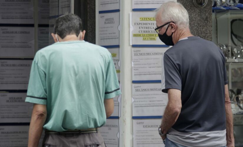 Pessoas procuram emprego em painel de vagas