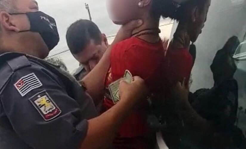 Policial segura jovem pelo pescoço durante abordagem em Iacanga 