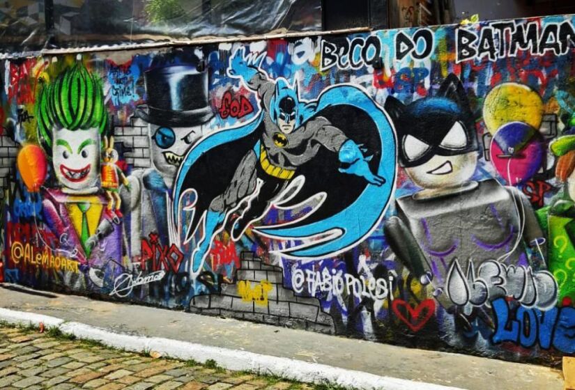 O nome do local vem de um grafite do personagem Batman, da DC Comics, que apareceu nos muros do bairro em 1980. Desde então, o Beco tem sido coberto por várias obras de arte, incluindo influências cubistas e psicodélicas, transformando-o em uma espécie de galeria ao ar livre. / Foto: Instagram/@becodobatman.oficial 