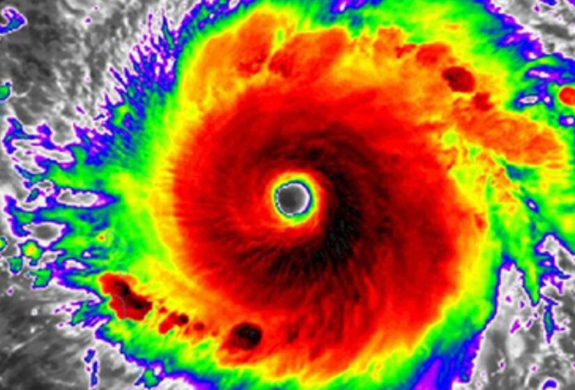 Uma imagem de satélite infravermelho do furacão Irma, 12 de setembro de 2017. Este tipo de imagem mede a temperatura do topo das nuvens. Quanto mais frio o topo da nuvem, mais alto ele se estende na atmosfera. As cores de verde a vermelho e preto ajudam a identificar os topos mais altos das nuvens, com as cores mais escuras sendo as nuvens mais altas. / Foto: Divulgação/NOAA
