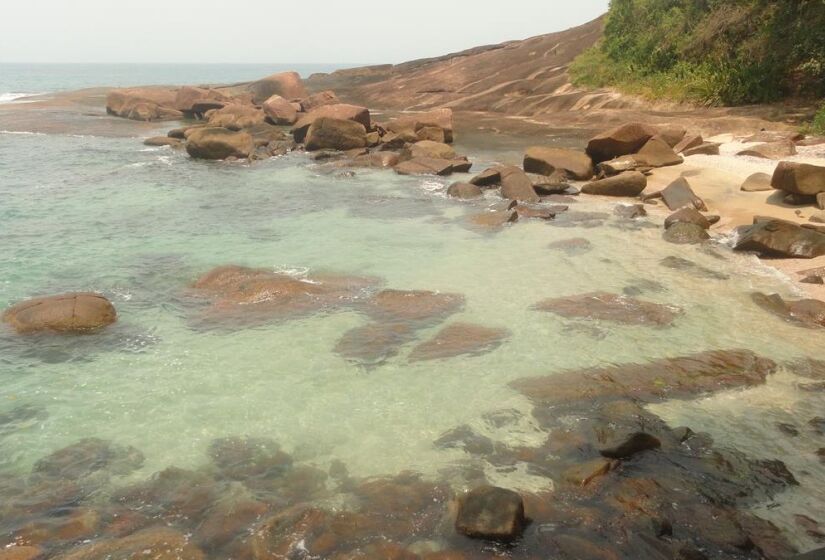 A praia é cercada por rochas que formam uma piscina natural de águas transparentes. Foto: Prefeitura de Ubatuba