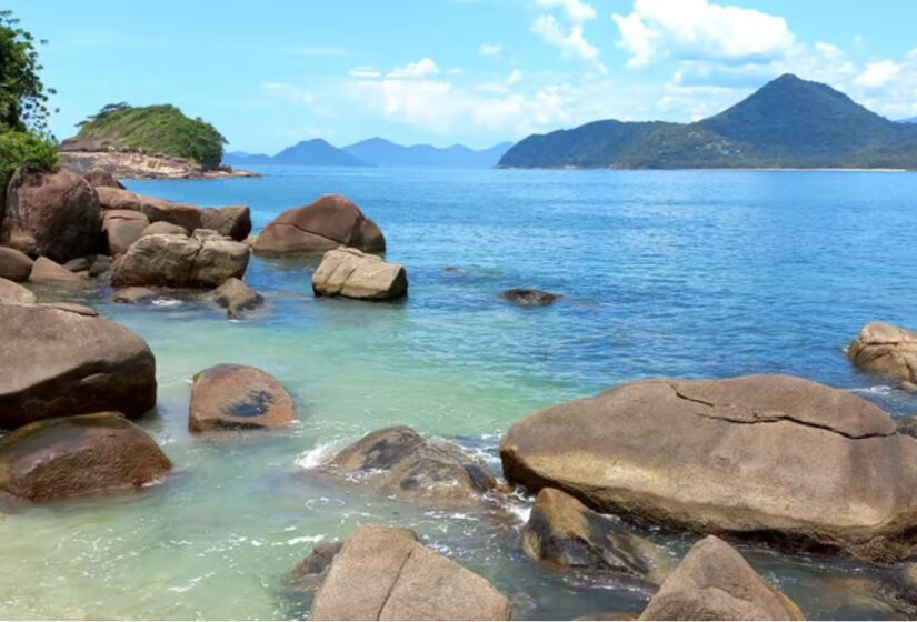 O acesso à Ilha do Prumirim se dá a partir da Praia do Prumirim, um local igualmente encantador com uma faixa de areia ampla e mar de tombo. A praia oferece ótimos quiosques e uma vista privilegiada da ilha, sendo o ponto de partida para os barcos que fazem a travessia. Foto: Divulgação/Caminho das Trilhas