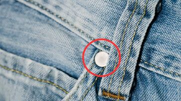 O nome do tecido é denim, criado em Nimes, França, e posteriormente adotado por Levi Strauss nos EUA 