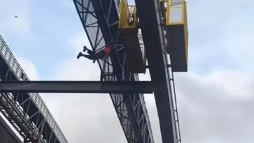 Imagens publicadas nas redes sociais mostram o trabalhador balançando, preso pelo cinto de segurança