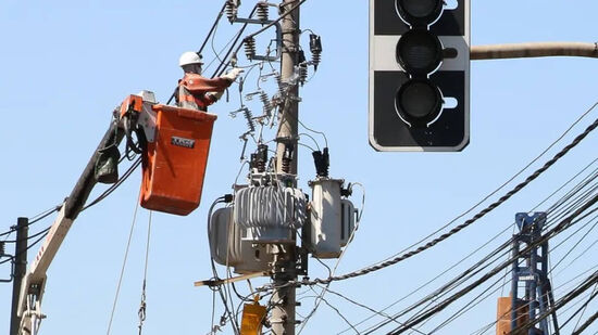 Funcionário da Enel trabalhando em um poste na capital de SP