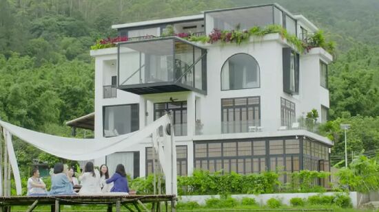 Casa, que ocupa três andares e meio, está situada em uma área cercada por colinas e arrozais