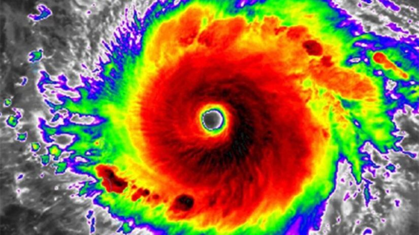 Uma imagem de satélite infravermelho do furacão Irma, 12 de setembro de 2017. Este tipo de imagem mede a temperatura do topo das nuvens. Quanto mais frio o topo da nuvem, mais alto ele se estende na atmosfera. As cores de verde a vermelho e preto ajudam a identificar os topos mais altos das nuvens, com as cores mais escuras sendo as nuvens mais altas. / Foto: Divulgação/NOAA
