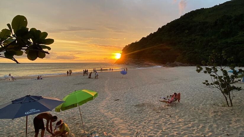 O pôr do sol na Praia de Santiago se destaca pelo céu colorido em tons vibrantes, do laranja ao violeta, e pelo efeito de contraluz da Ilha Montão de Trigo no horizonte. Foto: Divulgação