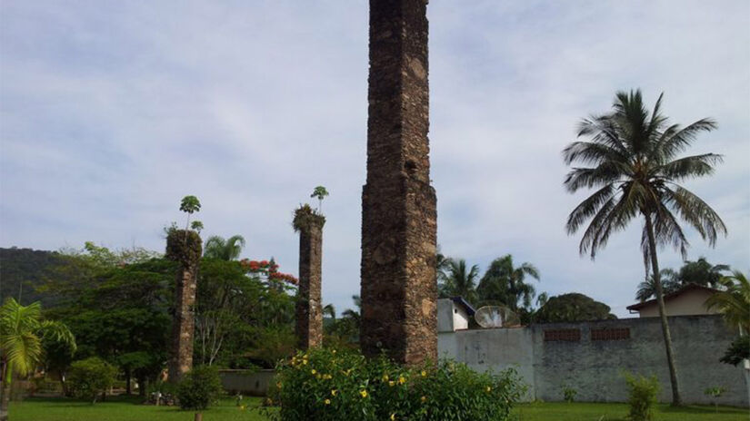 Restam em pé três colunas de sustentação em pedra e cal, do que teria sido a primeira fábrica de vidros do Brasil - Foto: Reprodução Fundart