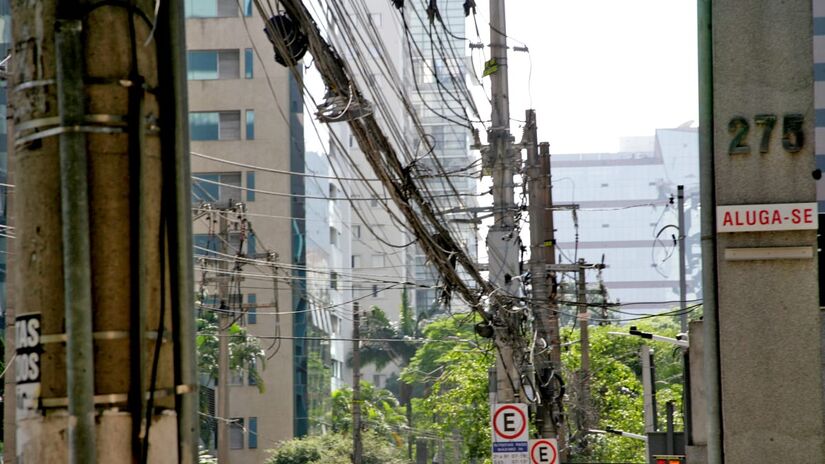 Fiação de postes na rua Helena, na Vila Olímpia. Via foi incluída em 2021 em iniciativa da Enel que prometia enterramento de fios. Foto: Thiago Neme/Gazeta de S. Paulo