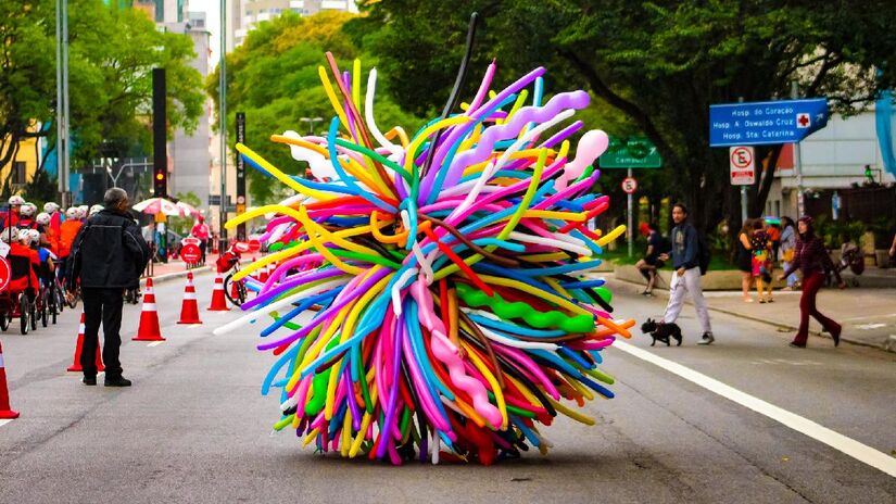 Coberto com dezenas de bexigas de diversas cores, artista se apresenta sobre patins. Foto: Fabrício Augusto