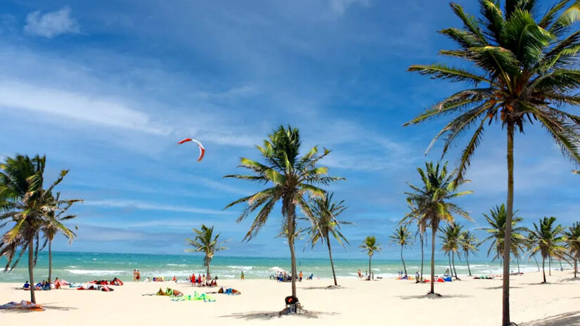 Praia do Cumbuco, em Caucaia - Paraíso do kitesurf, o local tem um mar de águas cristalinas, vento refrescante, opção de turismo entre as dunas, e uma das melhores opções no quesito estrutural. A praia possui uma longa extensão: são pelo menos 4 quilômetros de orla. Por lá, é possível aproveitar o sol perto dos bares ou relaxar em algum canto mais isolado - (Divulgação)