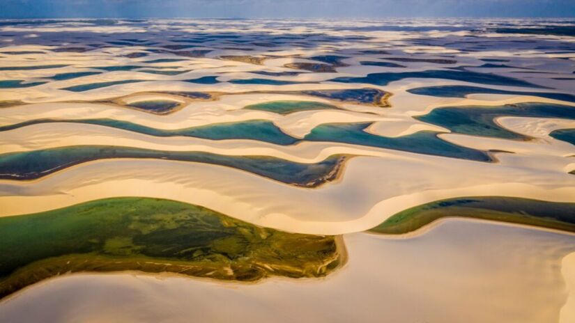 A dunas cercadas por lagoas de água doce compõem cerca de 57% da área do parque, que abriga mais de 100 espécies de plantas e animais em extinção como a ave guará, a lontra-neotropical, o gato-do-mato e o peixe-boi-marinho. Foto:  Christian Dimitrius/Parque Nacional dos Lençóis Maranhenses no Facebook/Reprodução