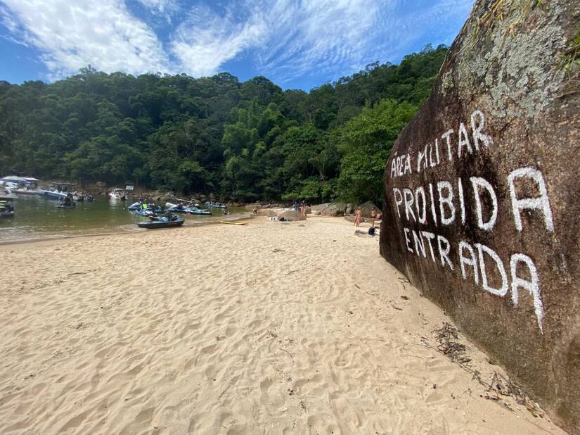 Logo na entrada da praia há uma inscrição informando que a área é exclusivamente militar, com entrada proibida.