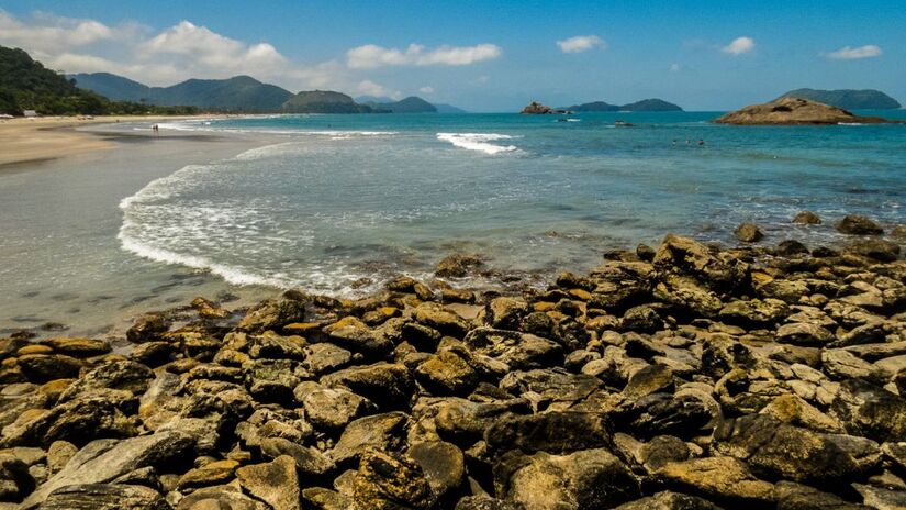 Praia da Jureia, São Sebastião: um refúgio natural cercado por mata atlântica e com um rio que deságua no mar, formando uma pequena lagoa perfeita para um banho de água doce. Com poucas barracas e movimento tranquilo, é ideal para quem busca sossego. Foto: Divulgação/turismo São Sebastião