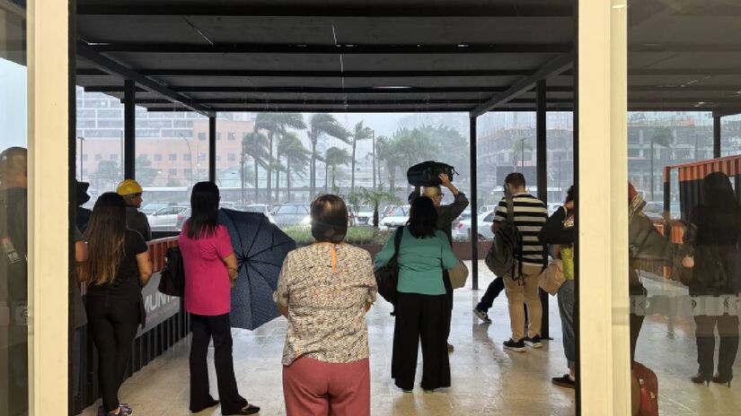 Clientes ficam em frente ao shopping e aguardam o temporal passar para sair. Foto: Isabela Alves