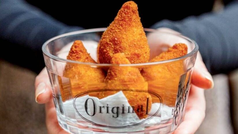 A coxinha Original sai por R$ 25 ou R$ 47, conforme o tamanho desejado, e é feita tradicionalmente com massa de batata baroa, frango desfiado e Catupiry.