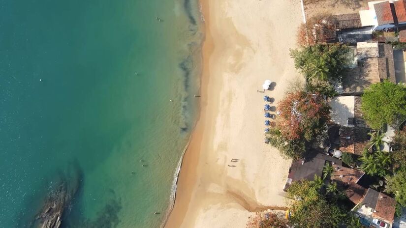 A Praia dos Castelhanos em Ilhabela é famosa pelo seu formato de coração. O acesso é feito apenas por barco ou por um passeio 4x4, que custa entre R$ 120 e R$ 140 para ida e volta. O trajeto 4x4, que é acidentado e controlado por veículos credenciados, passa por cachoeiras e oferece curiosidades sobre a Mata. A praia possui estrutura com restaurantes e um mirante de 140 degraus para apreciar a vista. É crucial usar muito repelente devido à grande quantidade de borrachudos, o que curiosamente indica a presença de água limpa e potável na área.