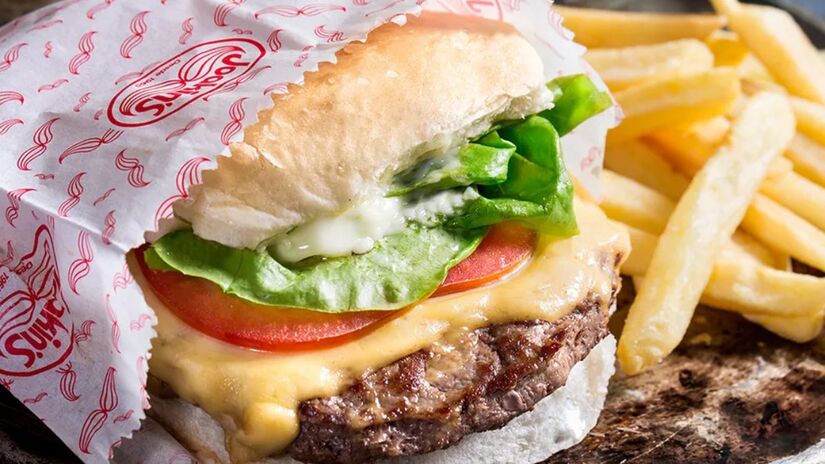Com mais de 50 anos de história, o Joakin's Hamburguer mantém um dos ambientes mais icônicos da cidade: sofás vermelhos, salão amplo e clima descontraído. O cheese salada (R$ 43,70) é a estrela do cardápio, feito com disco de carne de 120g, queijo, alface, tomate verde e a famosa maionese verde.

Foto: Reprodução/Divulgação