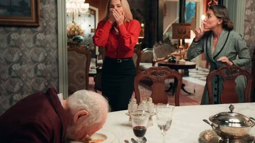 Sandra não desisitirá e, nos próximos capítulos do folhetim, com a ajuda de Inês colocará o veneno no prato de comida do marido, que tosse e cai debruçado na mesa. Fotos: Reprodução/TV Globo