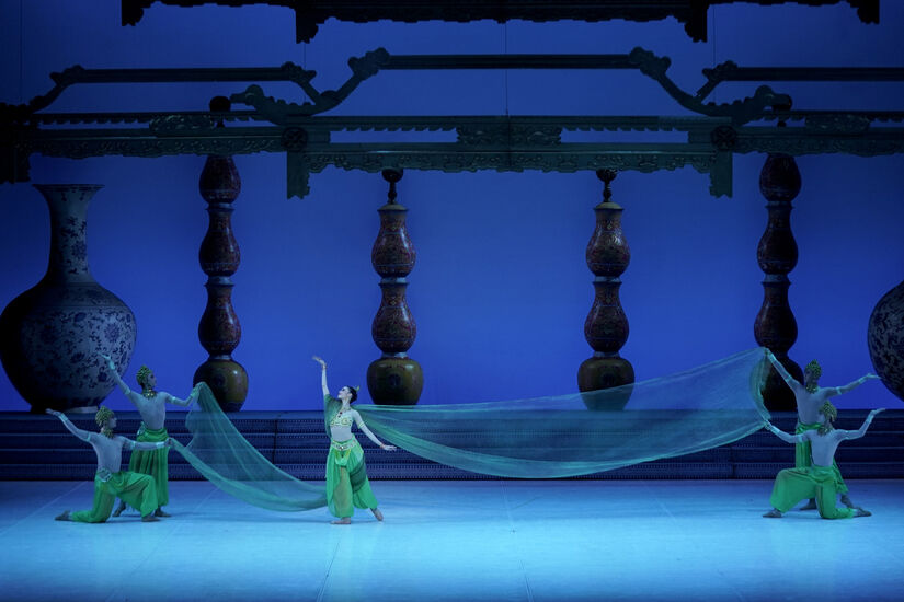 Símbolos como os doze animais do zodíaco, lanternas vermelhas e criaturas do folclore chinês transformam o clássico em uma jornada encantada entre realidade e sonho.